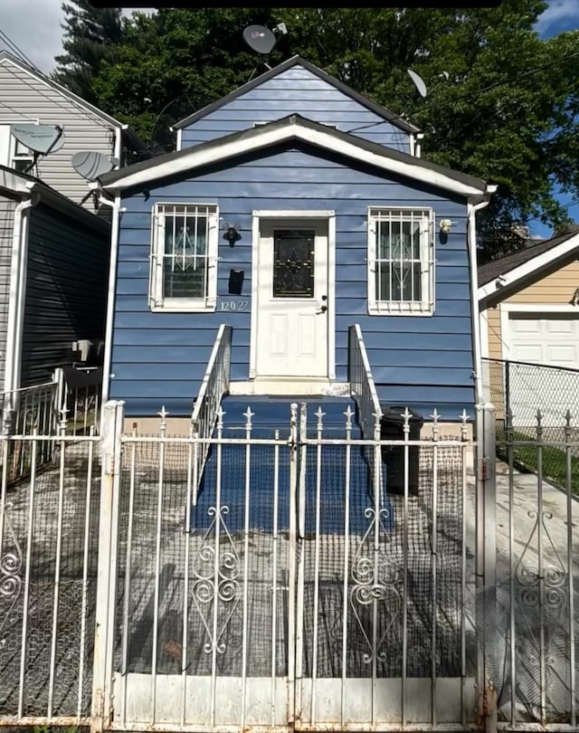 12027 140th St, Jamaica, NY 11436 - shotgun-style home with a fenced front yard and a gate