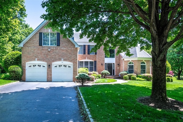 11 Pebble Beach Ln, White Plains, NY 10605 - view of front of house featuring asphalt driveway, a front lawn, brick siding, and an attached garage