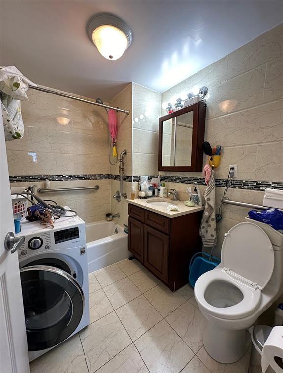 136-21 Latimer Pl Unit 5H, Flushing, NY 11354 - full bathroom with washer / dryer, tile walls, bathing tub / shower combination, marble look tile flooring, and vanity