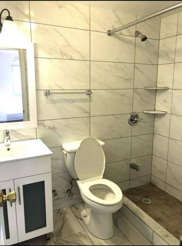 154-11 17th Ave, Whitestone, NY 11357 - bathroom featuring marble look tiles, vanity, a shower stall, toilet, and tile walls