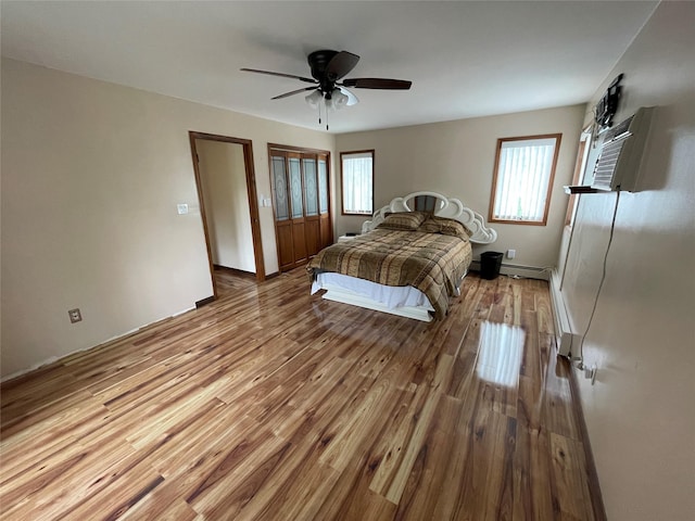 74 Webster Ave, West Islip, NY 11795 - bedroom featuring multiple windows, wood finished floors, ceiling fan, and a baseboard radiator