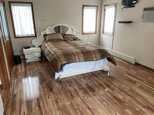 74 Webster Ave, West Islip, NY 11795 - bedroom featuring wood finished floors, an AC wall unit, and a baseboard heating unit