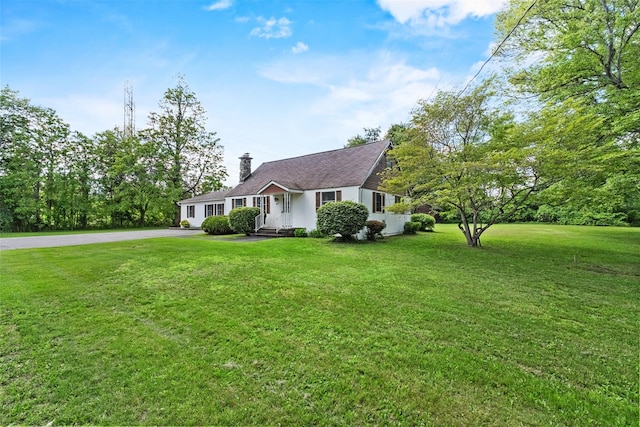 89 Brown Rd, Wappingers Falls, NY 12590 - view of front facade with asphalt driveway, a chimney, a front lawn, and a garage