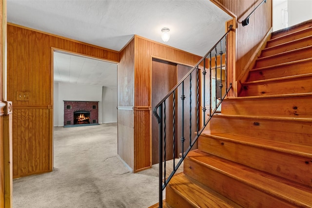 89 Brown Rd, Wappingers Falls, NY 12590 - staircase with carpet flooring, wooden walls, and a brick fireplace