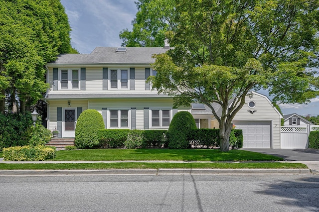 23 S Sixth St, Locust Valley, NY 11560 - view of front of home with asphalt driveway, a front lawn, an attached garage, and a chimney