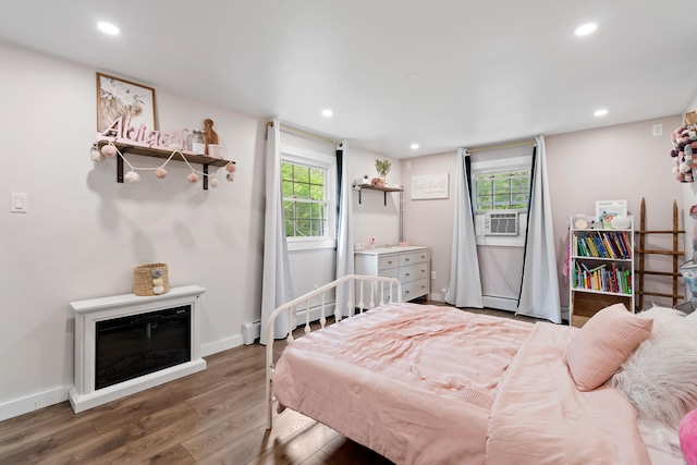 323 Harris Rd, Monticello, NY 12701 - bedroom with wood finished floors, baseboard heating, recessed lighting, baseboards, and cooling unit