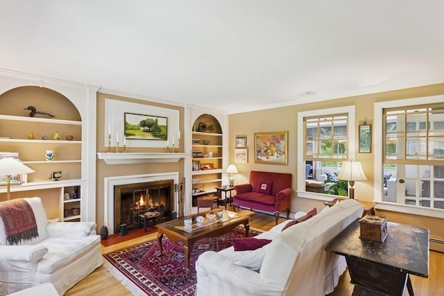 43 Hill St, Wading River, NY 11792 - living area with wood finished floors, built in features, a large fireplace, and ornamental molding