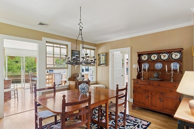 43 Hill St, Wading River, NY 11792 - dining space with a chandelier, light wood-style flooring, and ornamental molding