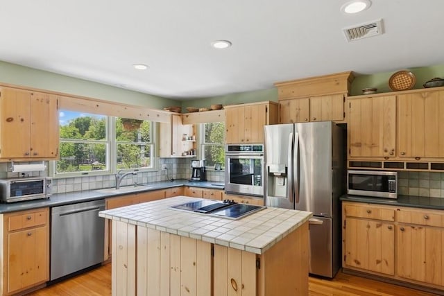 43 Hill St, Wading River, NY 11792 - kitchen featuring appliances with stainless steel finishes, tasteful backsplash, a center island, light wood-style flooring, and recessed lighting