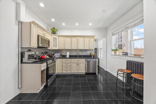 27 Locust Ave Unit 4N, New Rochelle, NY 10801 - kitchen featuring appliances with stainless steel finishes, cream cabinetry, dark countertops, recessed lighting, and dark tile patterned floors
