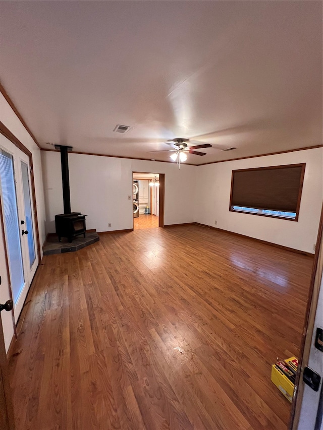 6 Farmingdale Ln, Bloomingburg, NY 12721 - unfurnished living room with a wood stove, wood finished floors, and ceiling fan