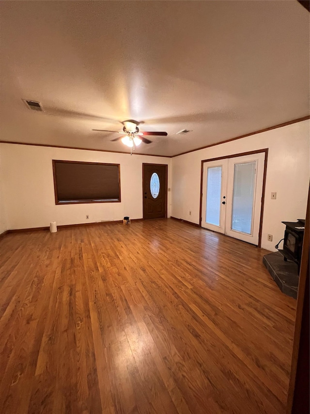 6 Farmingdale Ln, Bloomingburg, NY 12721 - unfurnished living room with a wood stove, french doors, ceiling fan, wood finished floors, and baseboards