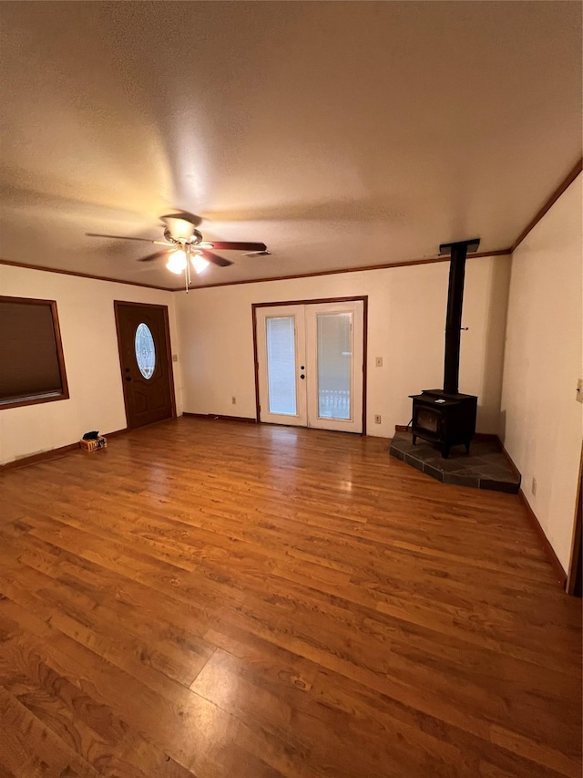 6 Farmingdale Ln, Bloomingburg, NY 12721 - unfurnished living room with wood finished floors, a ceiling fan, a wood stove, french doors, and baseboards