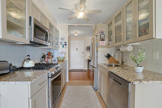 103 Gedney St Unit 2N, Nyack, NY 10960 - kitchen featuring stainless steel appliances, a sink, decorative backsplash, light stone countertops, and ceiling fan