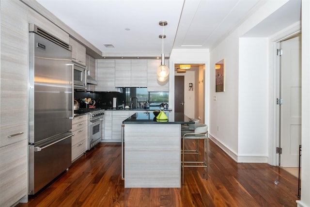 5 Renaissance Sq Unit 17B, White Plains, NY 10601 - kitchen featuring built in appliances, dark countertops, modern cabinets, a breakfast bar area, and a center island