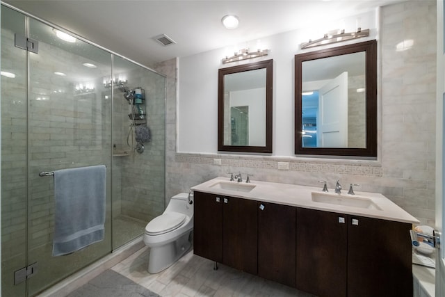 5 Renaissance Sq Unit 17B, White Plains, NY 10601 - bathroom with double vanity, tile walls, toilet, and a shower stall
