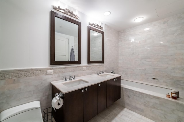 5 Renaissance Sq Unit 17B, White Plains, NY 10601 - bathroom with tile walls, toilet, double vanity, and tiled bath