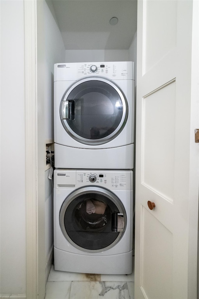 5 Renaissance Sq Unit 17B, White Plains, NY 10601 - laundry area featuring estacked washer and dryer and marble finish floors