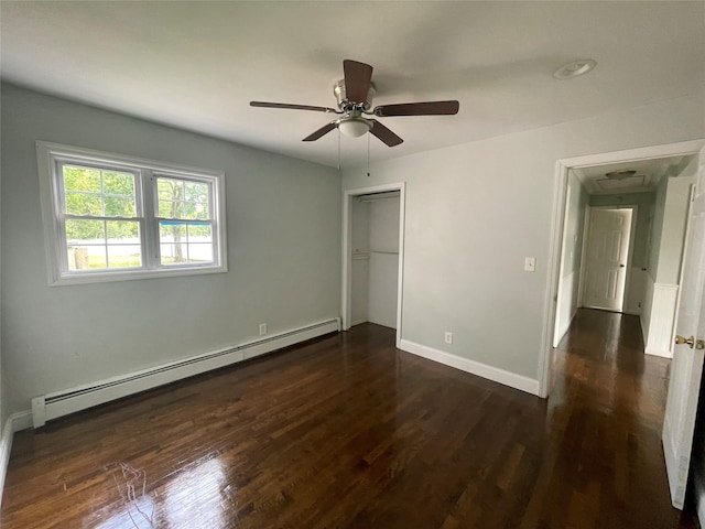 10 Kirby Ln, Central Islip, NY 11722 - unfurnished bedroom featuring baseboard heating, dark wood-style floors, a closet, baseboards, and a ceiling fan