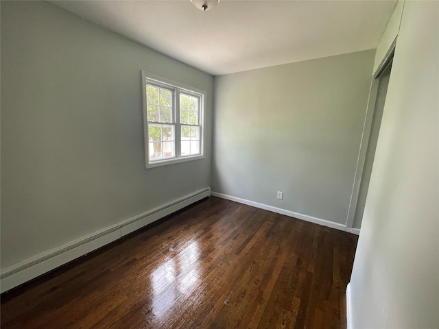 10 Kirby Ln, Central Islip, NY 11722 - unfurnished room with baseboard heating, dark wood-style flooring, and baseboards