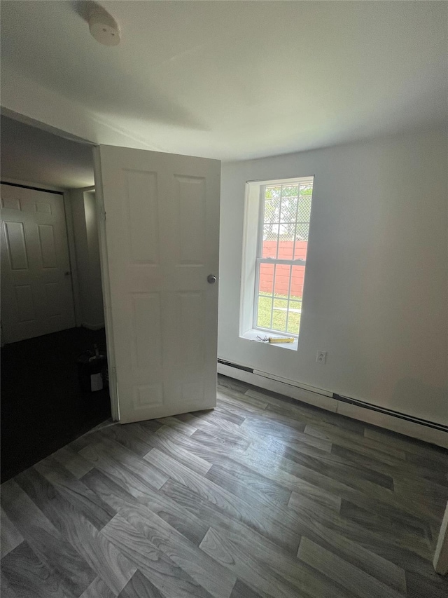 10 Kirby Ln, Central Islip, NY 11722 - unfurnished bedroom featuring wood finished floors and a baseboard heating unit