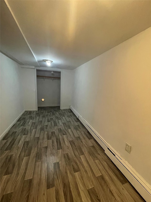 10 Kirby Ln, Central Islip, NY 11722 - finished basement with a baseboard heating unit, dark wood finished floors, and baseboards