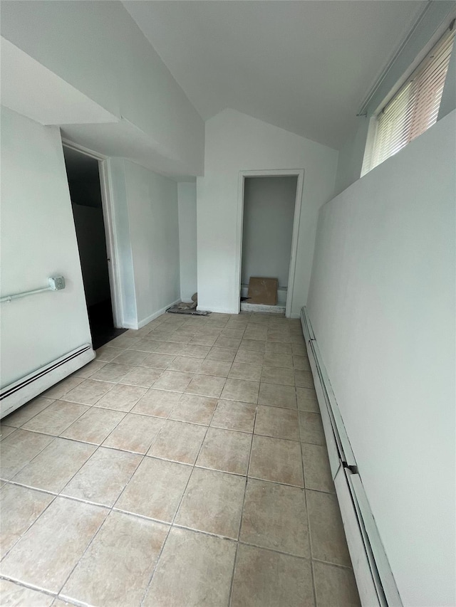 10 Kirby Ln, Central Islip, NY 11722 - empty room with vaulted ceiling, light tile patterned flooring, baseboard heating, and a baseboard radiator