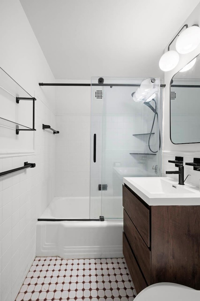 3135 Johnson Ave Unit 9A, Bronx, NY 10463 - bathroom featuring vanity, combined bath / shower with glass door, toilet, tile walls, and tile patterned flooring