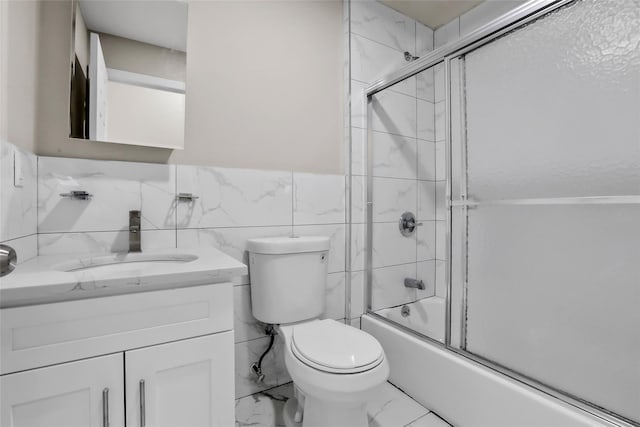 305 Union Ave, New Rochelle, NY 10801 - bathroom with marble finish floors, vanity, toilet, bath / shower combo with glass door, and tile walls