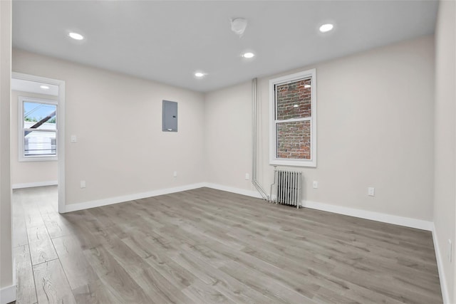 305 Union Ave, New Rochelle, NY 10801 - unfurnished room with radiator heating unit, electric panel, light wood-style flooring, baseboards, and recessed lighting