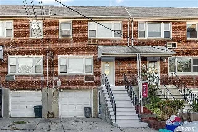 5-41 117th St, College Point, NY 11356 - townhome / multi-family property featuring driveway, brick siding, and an attached garage
