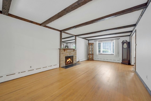 115 Fowler Ave, Yonkers, NY 10701 - unfurnished living room featuring a baseboard heating unit, beam ceiling, wood finished floors, a stone fireplace, and baseboards