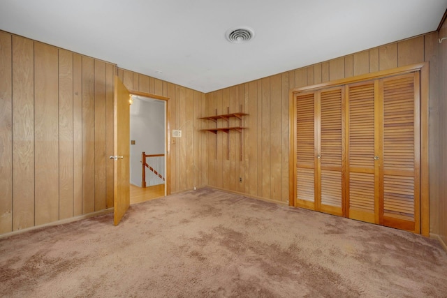 115 Fowler Ave, Yonkers, NY 10701 - unfurnished bedroom with carpet flooring, wood walls, and a closet