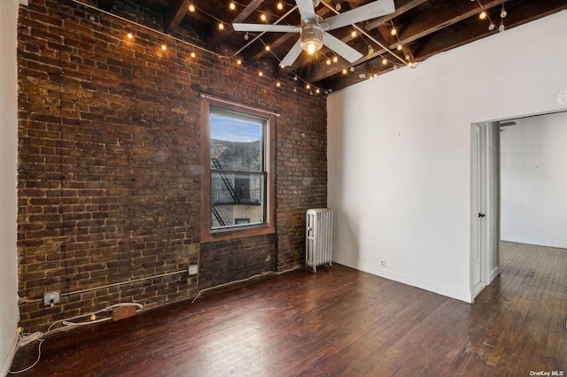 21-16 35th St Unit 5B, Astoria, NY 11105 - empty room featuring radiator heating unit, beam ceiling, wood-type flooring, a ceiling fan, and brick wall