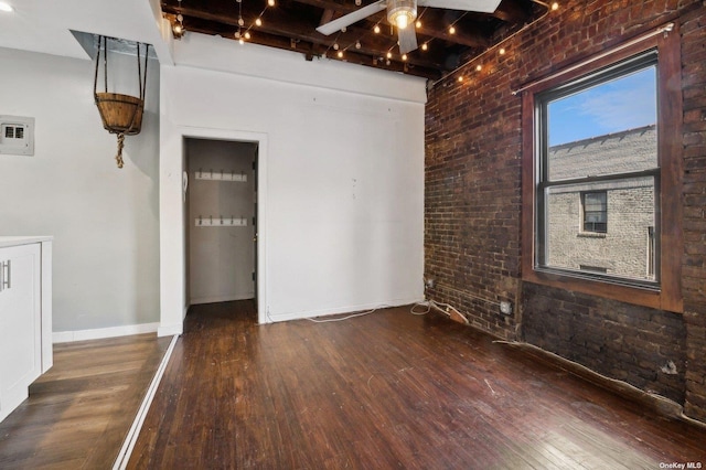 21-16 35th St Unit 5B, Astoria, NY 11105 - spare room with ceiling fan, wood finished floors, beam ceiling, brick wall, and baseboards