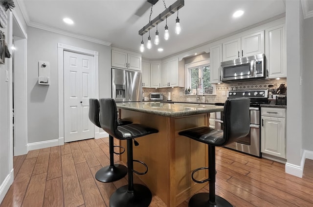 20 Shale Dr, Wappingers Falls, NY 12590 - kitchen featuring appliances with stainless steel finishes, light wood-type flooring, baseboards, white cabinetry, and crown molding