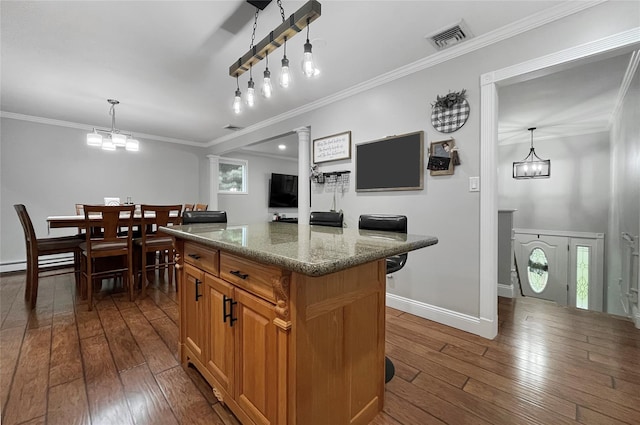 20 Shale Dr, Wappingers Falls, NY 12590 - kitchen with dark wood-type flooring, a center island, ornamental molding, stone counters, and pendant lighting
