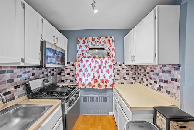 35 Lawrence Dr Unit A, White Plains, NY 10603 - kitchen featuring appliances with stainless steel finishes, radiator heating unit, a sink, and light countertops