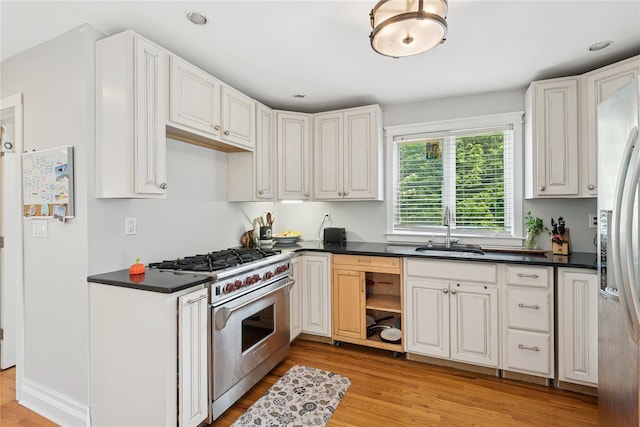 17 Tulip Rd, Rocky Point, NY 11778 - kitchen with stainless steel appliances, a sink, dark countertops, light wood-style flooring, and white cabinets