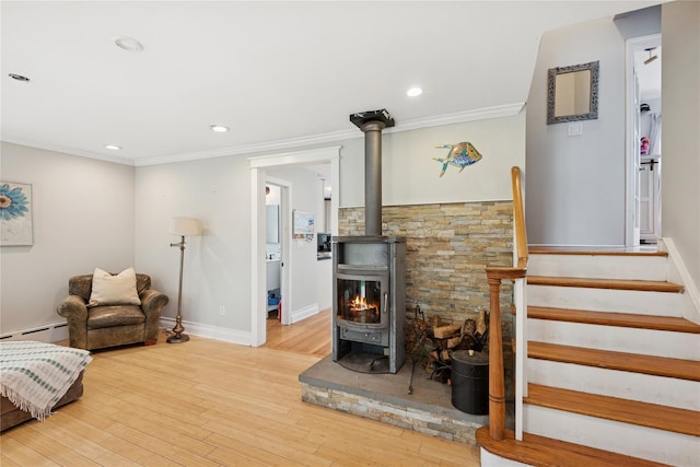 17 Tulip Rd, Rocky Point, NY 11778 - living area featuring a wood stove, light wood-style floors, baseboard heating, crown molding, and baseboards