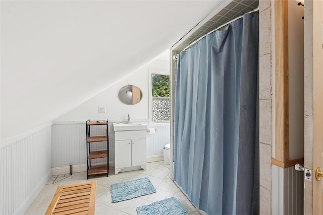 17 Tulip Rd, Rocky Point, NY 11778 - full bath featuring vanity, toilet, tile patterned flooring, a wainscoted wall, and lofted ceiling
