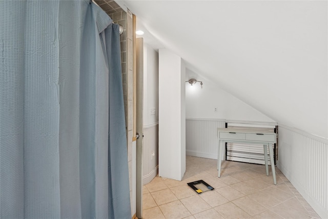 17 Tulip Rd, Rocky Point, NY 11778 - additional living space featuring vaulted ceiling, tile patterned floors, and wainscoting