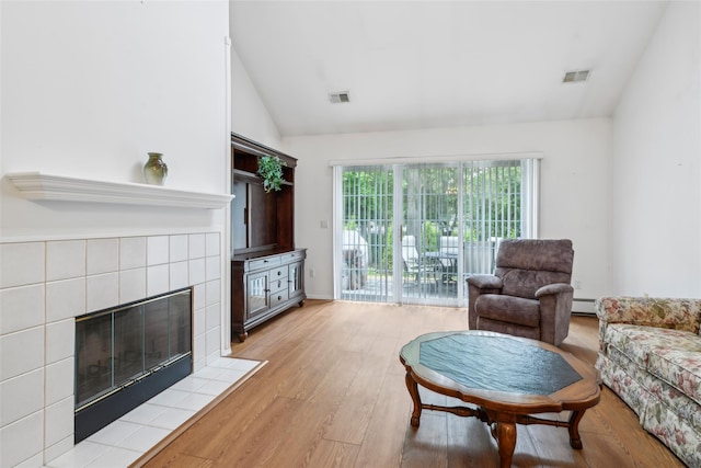 30 Joyces Way, Bay Shore, NY 11706 - living area with vaulted ceiling, light wood-type flooring, a tile fireplace, and baseboard heating