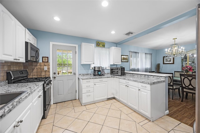 24 Sugarwood Ln, Commack, NY 11725 - kitchen with stainless steel range with gas cooktop, a peninsula, a chandelier, white cabinetry, and light stone countertops