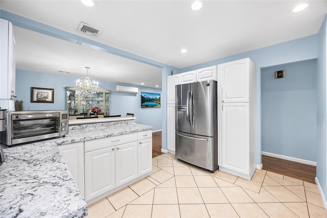 24 Sugarwood Ln, Commack, NY 11725 - kitchen featuring stainless steel fridge, a wall mounted air conditioner, a chandelier, light stone countertops, and white cabinets