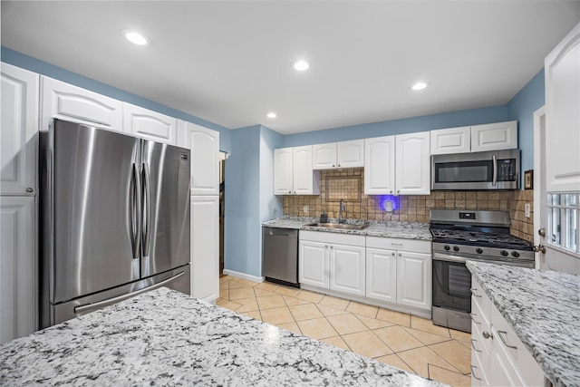 24 Sugarwood Ln, Commack, NY 11725 - kitchen featuring appliances with stainless steel finishes, a sink, tasteful backsplash, light stone countertops, and recessed lighting