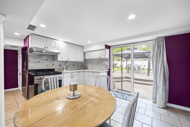 24 Sugarwood Ln, Commack, NY 11725 - kitchen featuring stainless steel gas stove, under cabinet range hood, light countertops, backsplash, and baseboards