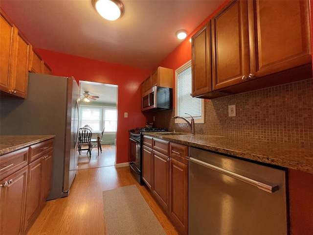 42 Saint Marks Ave, Freeport, NY 11520 - kitchen with stainless steel appliances, light wood-type flooring, ceiling fan, tasteful backsplash, and brown cabinets