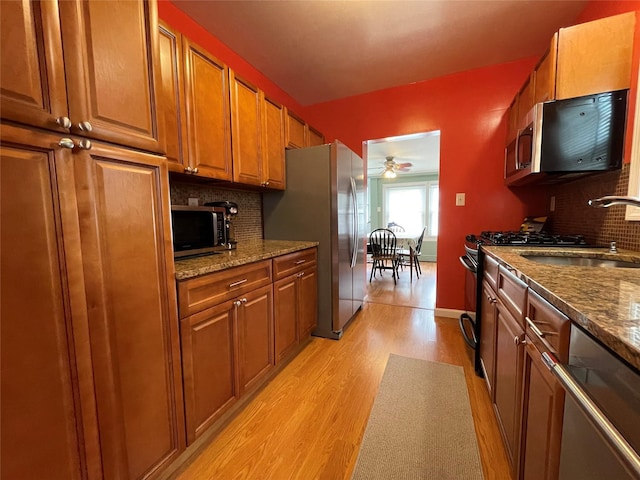 42 Saint Marks Ave, Freeport, NY 11520 - kitchen featuring stainless steel appliances, light wood-style flooring, ceiling fan, and decorative backsplash