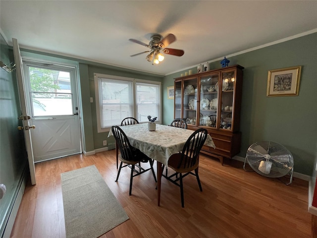 42 Saint Marks Ave, Freeport, NY 11520 - dining space featuring ceiling fan, plenty of natural light, light wood-style floors, ornamental molding, and a baseboard heating unit